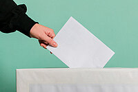 Arm, der einen Wahlzettel in eine U18-Wahlurne einwirft