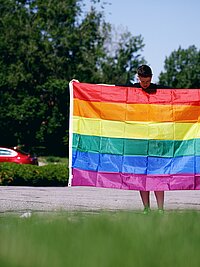 Eine Person mit Regenbogenflagge.