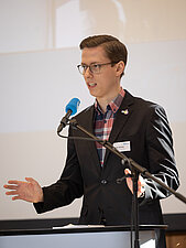Malte Scholz berichtet als Vorsitzender der Kommission Queere Jugendarbeit