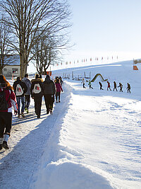 Schüler:innen der teilnehmenden Schulklassen in der Schneelandschaft des Kinderdorfs Pestalozzi 