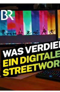 Ein Screenshot von einem Video von "Lohnt sich das?" über Digital-Streetwork-Bayern. Zu sehen ist ein junger Streetworker, der vor einigen DOTA-2 Plakaten sitzt und nett in die Kamera lächelt.