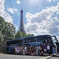 Schüler:innen vor Bus unterm Eiffelturm