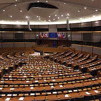 Die Stuhlreihen im Europäischen Parlament sind halbrund und nach Fraktionen unterteilt aufgestellt.