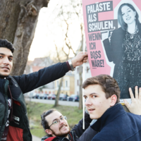 Drei junge Männer im Freien mit einem Plakat: Wenn ich Boss wäre!