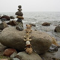 Steinturm auf einem großen Stein vor dem Meer