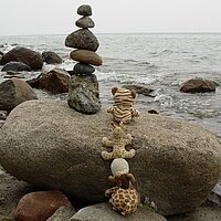 Steinturm auf einem großen Stein vor dem Meer